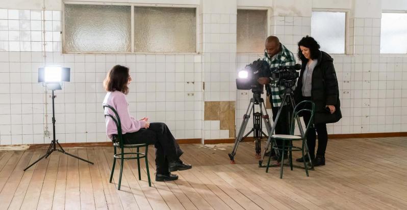 aluna sentada e jornalista e câmara prontos para entrevista 