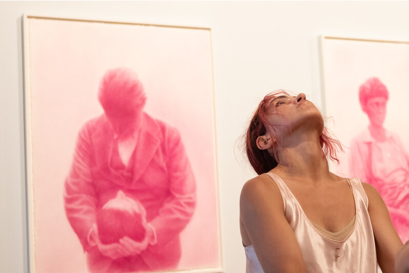 foto interprete com fundo da exposição 