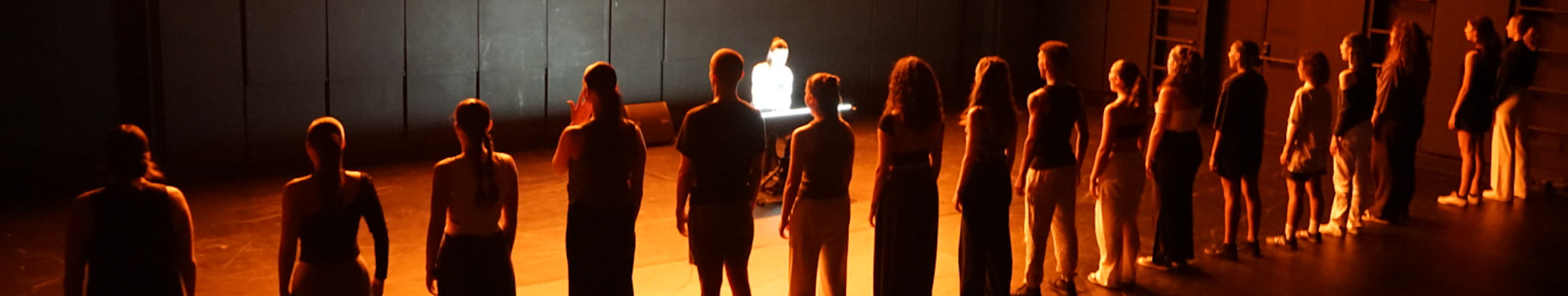 bailarinos em linha a cantar em cena